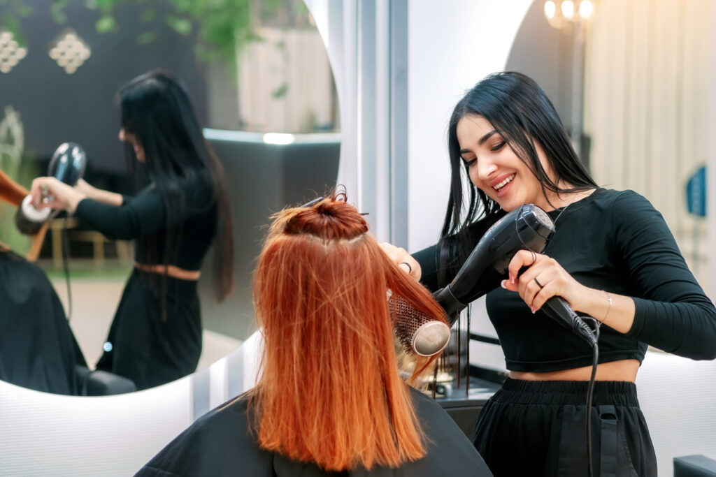 A woman getting her hair done by another person.