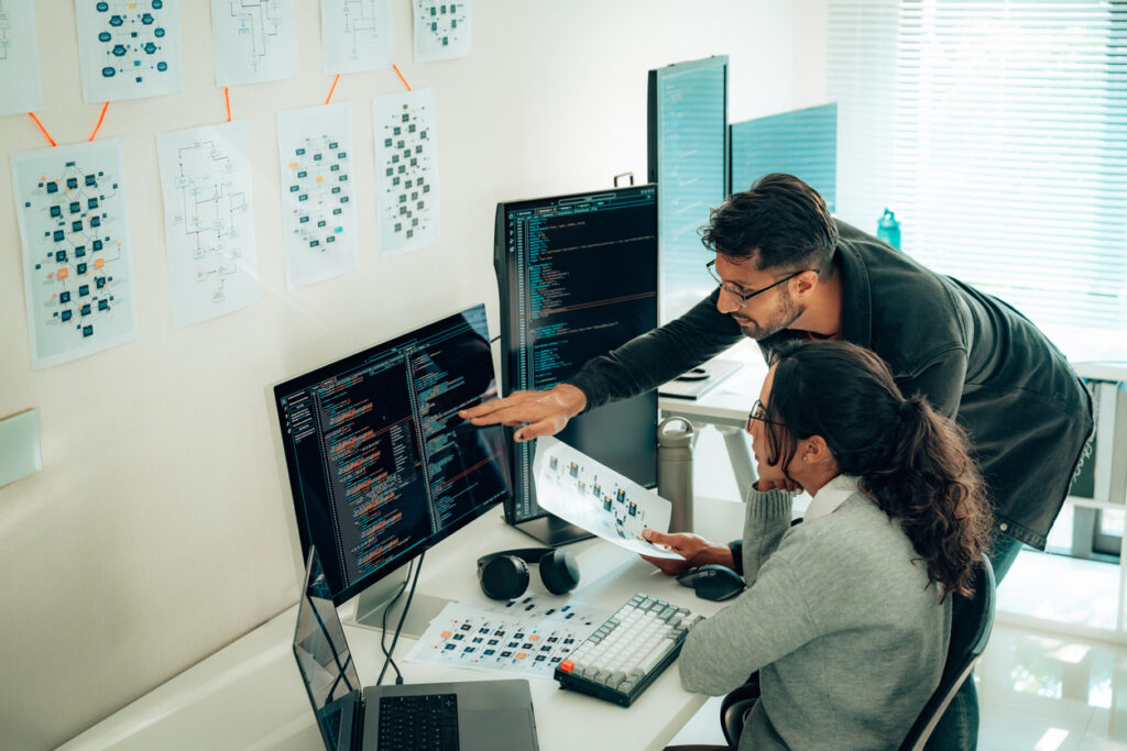 Two people working on computers in a room.